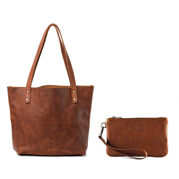 Fore Street Tote Bag by Rogue Industries, a brown leather tote bag with a matching wristlet pouch, crafted in Maine from luxurious full-grain leather and set against a white background.